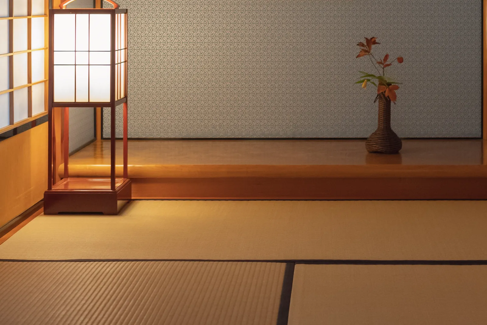 A tatami tea-room alcove with a paper lantern and a single autumn branch in a vase; a general photograph of a tea room in Kanazawa, not of this tea house
